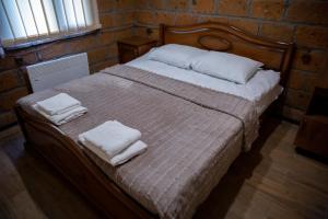 1 dormitorio con 1 cama con 2 toallas en Noravank L-and-L, en Namazalu