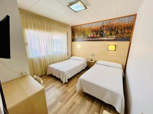 a hospital room with two beds and a painting on the wall at Tortosa Parc in Tortosa