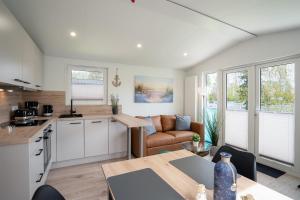a kitchen and living room with a table and a couch at Ostseecamp Ferienhaus "Horizont" in Scharbeutz