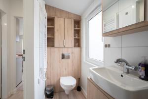 a bathroom with a white toilet and a sink at Ostseecamp Ferienhaus "Horizont" in Scharbeutz +36 photos