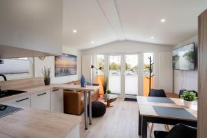 a kitchen and living room with a table and chairs at Ostseecamp Ferienhaus "Koralle" in Scharbeutz