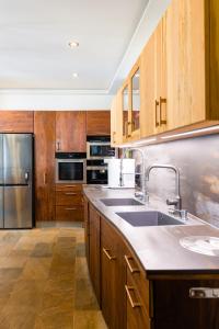 een keuken met houten kasten en een roestvrijstalen koelkast bij Eigner Suite 100 qm - Loft mit Ausblick in Calera