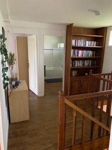 a room with a staircase and a book shelf with books at Les Roseries Boutique Gite in Clussais-la-Pommeraie