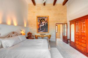 - une chambre avec un lit et une peinture murale dans l'établissement Dar il-Wied Farmhouse, à L-Għarb