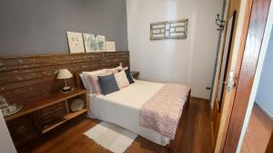 a bedroom with a bed with a wooden headboard at Suítes em casa centenária no centro de Socorro in Socorro