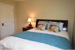 a bedroom with a bed with blue and white sheets and a lamp at Palo Alto Quiet 1 Bedroom Stanford University in Palo Alto