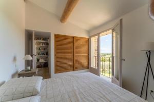 ein Schlafzimmer mit einem weißen Bett und einem Balkon in der Unterkunft Villa Les Terrasses de Gordes in Gordes + 24 Fotos