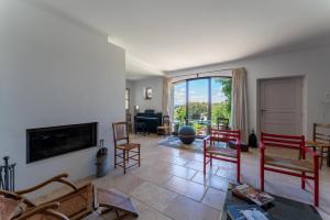 ein Wohnzimmer mit Stühlen und einem Flachbildfernseher in der Unterkunft Villa Les Terrasses de Gordes in Gordes