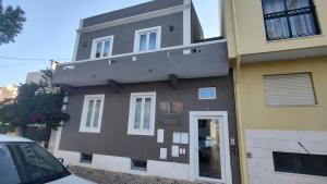 a black building with a balcony on the side of it at Costa Paradise Beach in Costa da Caparica