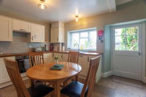 a kitchen with a wooden table and a table and chairs at Drury's in Corfe Castle