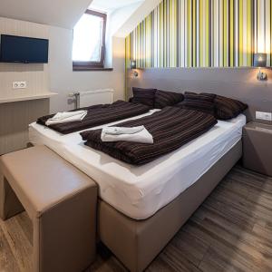 1 dormitorio con 2 camas y toallas. en Gasthaus Panzió, en Szilvásvárad