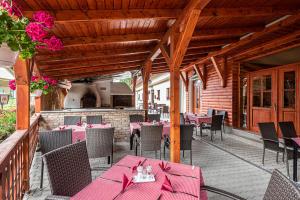 un restaurante con mesas rosas y sillas en un patio en Gasthaus Panzió, en Szilvásvárad