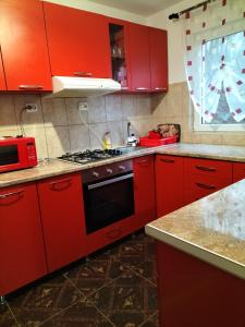 a kitchen with red cabinets and a stove top oven at Casă de vacanță Lidia in Albac