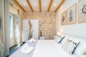 una camera da letto con un grande letto bianco con cuscini di Apartment SeventySeven a Dubrovnik