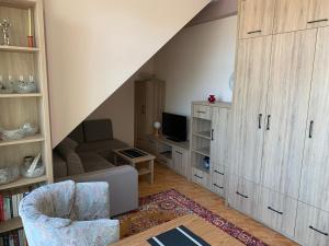 - un salon mansardé avec un canapé et une chaise dans l'établissement Apartament Iwona, à Mrągowo