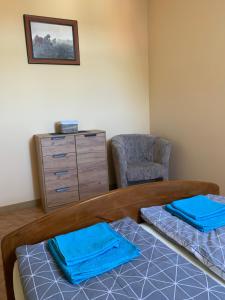 Cette chambre comprend un lit, une commode et une chaise. dans l'établissement Apartament Iwona, à Mrągowo