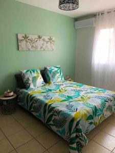 - une chambre avec un lit et une couette colorée dans l'établissement Villa Fleurs de Cannes 4*, à Saint-Louis