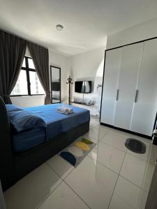 um quarto com uma cama azul e uma grande janela em Desaru Dhancell Executive Homestay All Bedrooms With NETFLIX em Desaru