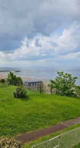a field of green grass with the ocean in the background at Bright apartment with sea view in Trouville-sur-Mer
