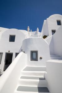 a staircase leading up to a white building at IKIES Santorini in Oia