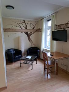 a living room with a tree mural on the wall at Gästehaus Villa Seraphinum in Dresden