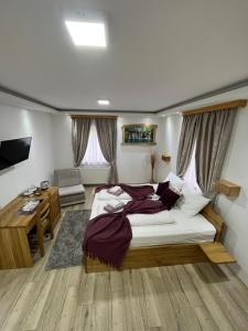 a bedroom with a large bed and a desk at Rustic Inn River in Plitvička Jezera