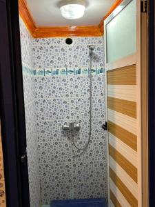 ein Bad mit einer Dusche mit einem blauen Stuhl in der Unterkunft Merzouga Camp and Hostel in Merzouga