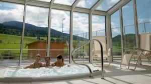 two children in a hot tub in a room with windows at Apartmány U stezek in Lipova Lazne