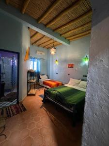 a bedroom with a bed in a room at Merzouga Camp and Hostel in Merzouga