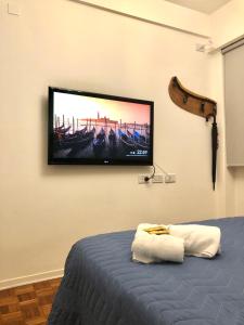TV de pantalla plana en una pared sobre una cama en Departamento Recoleta I en Buenos Aires