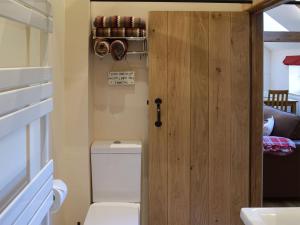 a bathroom with a toilet and a wooden door at The Granary in North Kilvington