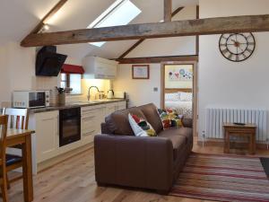 a living room with a couch and a kitchen at The Granary in North Kilvington