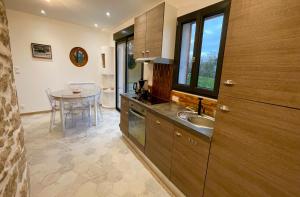 a kitchen with a sink and a table at MOULIN DE KERNOT in Cléden-Cap-Sizun