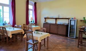 ein Restaurant mit Tischen und Stühlen sowie einem Kühlschrank in der Unterkunft Gästehaus Villa Seraphinum in Dresden