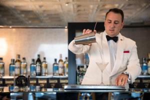 a man in a tuxedo making a drink at Grand Hotel Parker's in Naples