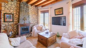 sala de estar con 2 sofás y chimenea en Villa Jarana Competa by Ruralidays en Cómpeta