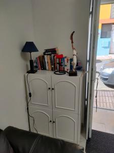 un armario blanco con una lámpara y libros. en Casa Alba 1, en Puerto del Rosario