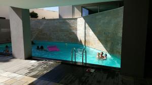 um grupo de pessoas a nadar numa piscina em Apartamento SUNSET T3 em São Martinho do Porto