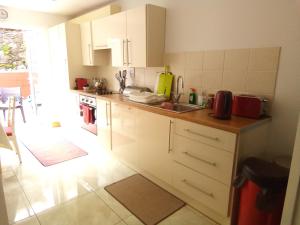 a kitchen with white cabinets and a sink at Church Street Cottage in Rosscarbery