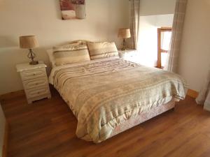 a bedroom with a bed and a nightstand and two lamps at Church Street Cottage in Rosscarbery +13 photos