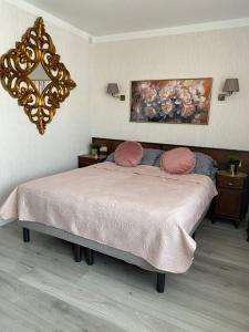1 dormitorio con 1 cama con sábanas rosas y espejo en Apartament blisko morza Carmen en Kołobrzeg