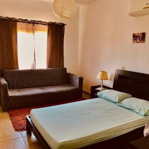 1 dormitorio con 1 cama, 1 sofá y 1 silla en Chalet Marina Wadi Degla Families Only Pool view 2nd floor 6 adults, en Ain Sokhna