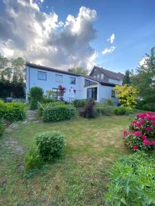 a white house with a yard with flowers at Apartments-Badharzburg / Ferienwohnung im Zentrum in Bad Harzburg