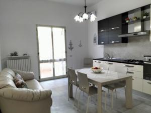 a kitchen and dining room with a table and a couch at Casa sole e luna in Porto Cesareo
