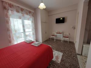 a bedroom with a red bed and a table with chairs at Crystal Home near Airport in Artemida