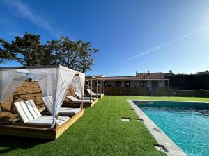 a group of lounge chairs next to a swimming pool at Quinta da Boavista in Vila Nova de Milfontes