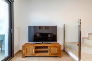 sala de estar con mesa y TV en PANORAMIC private pool home, en Finestrat