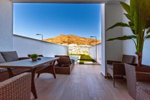 una sala da pranzo con tavolo, sedie e montagna di PANORAMIC private pool home a Finestrat