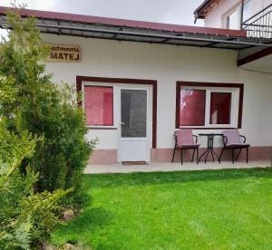 ein Haus mit zwei Stühlen und einem Tisch im Hof in der Unterkunft Apartment Matej in Kruševo