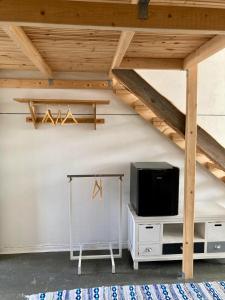 ein Wohnzimmer mit einem TV auf einem Stand und ein Loft in der Unterkunft Kotapiha in Liperi